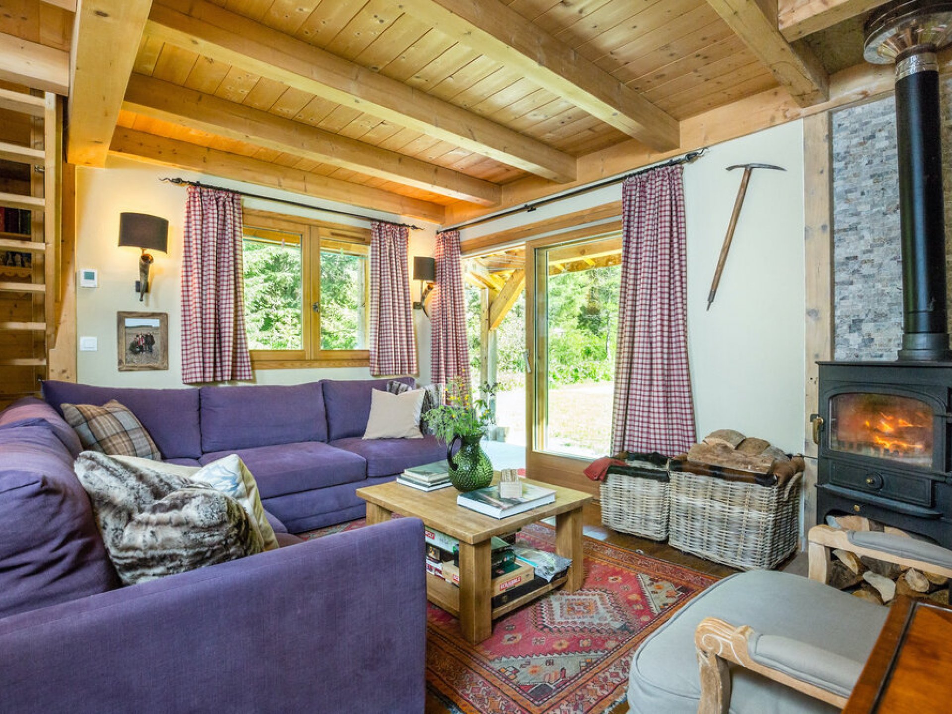 Chalet lounge with purple sofa and curtains.