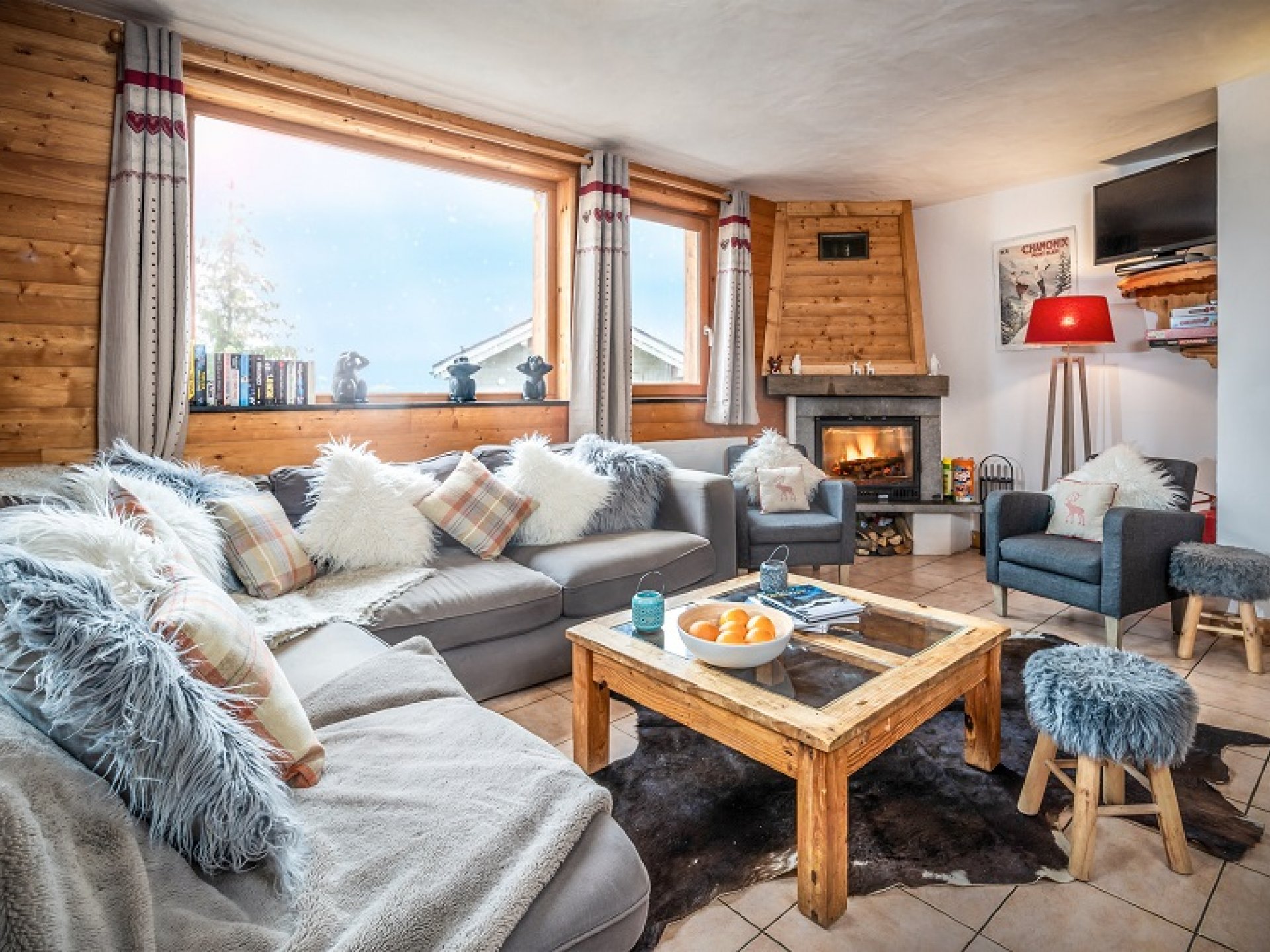 A cosy chalet lounge with sofa and log-fire